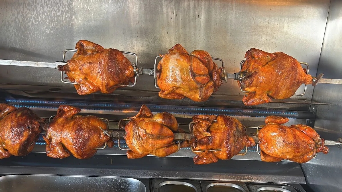 Ocho pollos dorándose en el rostizador de Los Medina
